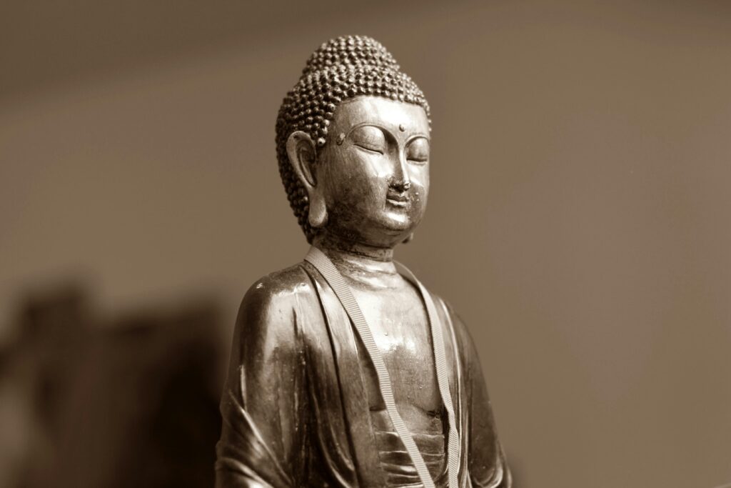 Close-up of a serene silver Buddha statue, highlighting Buddhist spirituality and art.